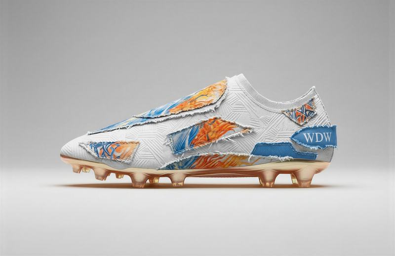 Soccer cleat with orange and blue patchwork
