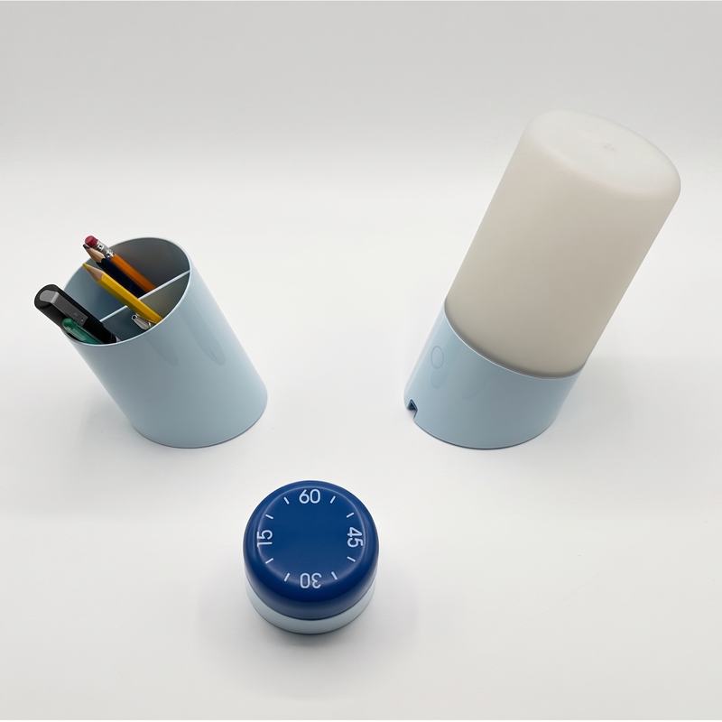 Lamp, pencil cup and timer in a studio setting